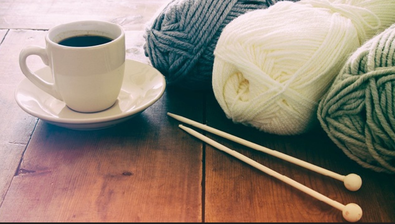 tasse à café et pelotes de laine et aiguilles