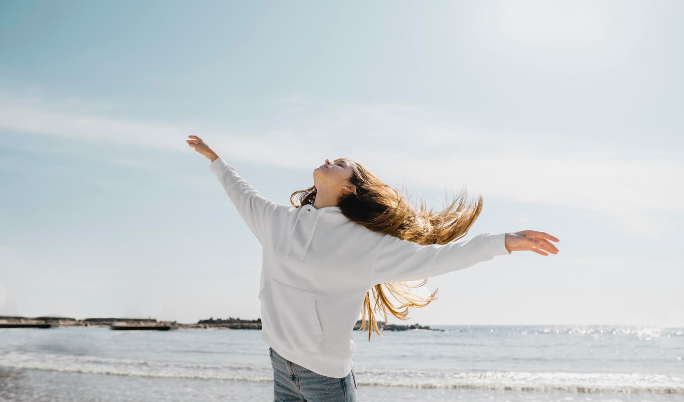 FEMME BRAS OUVERT DEVANT OCEAN