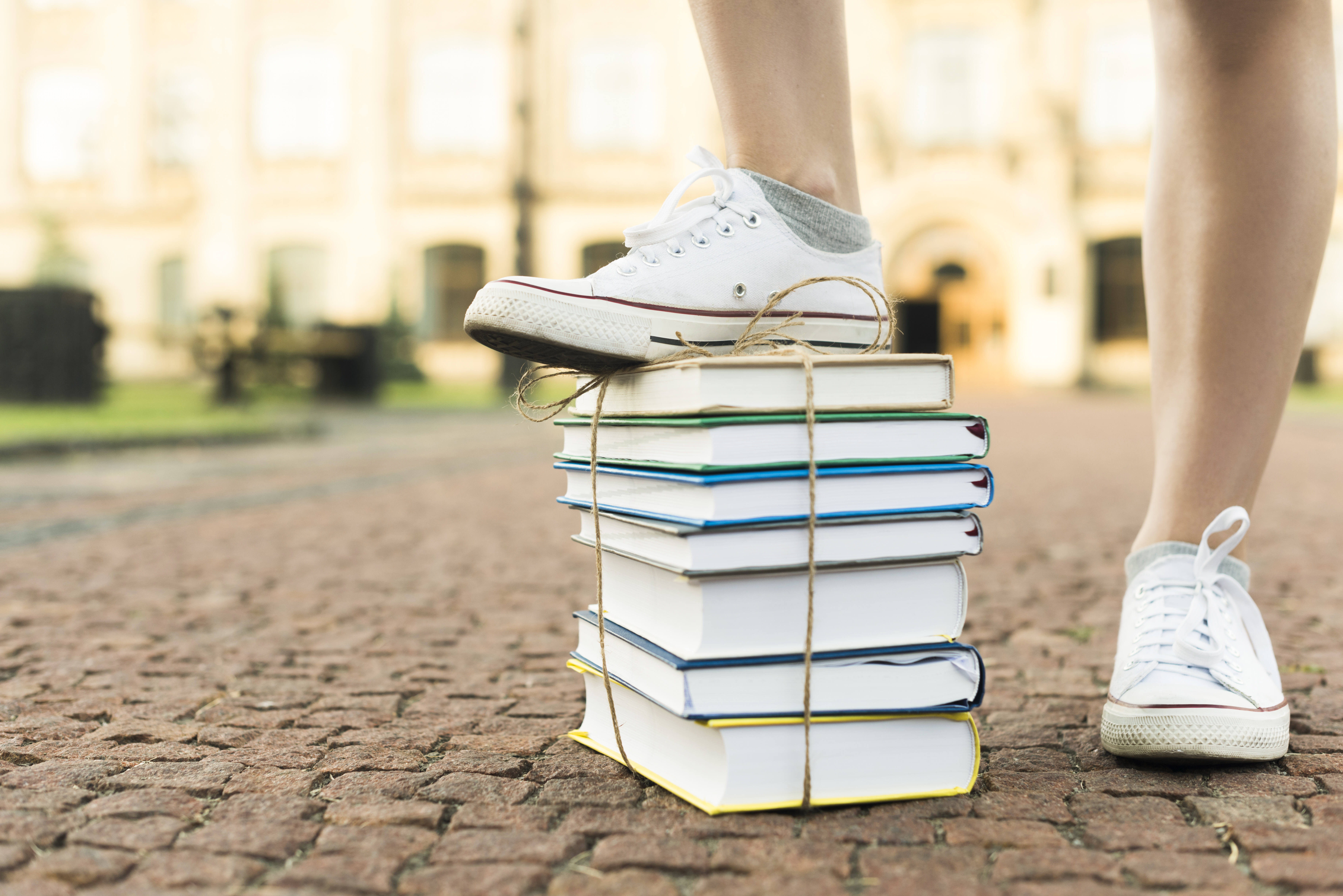 une pile de livre sous une chaussure