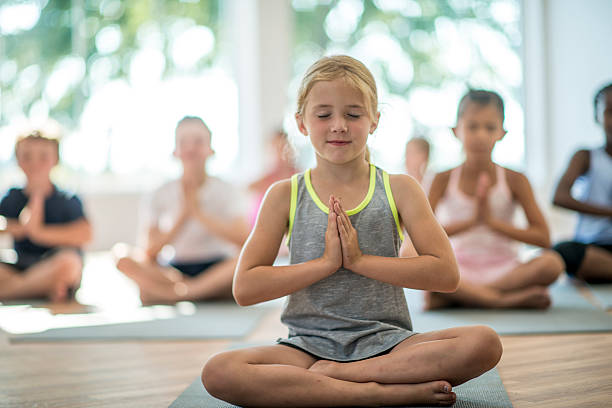 une enfant médite en position yoga