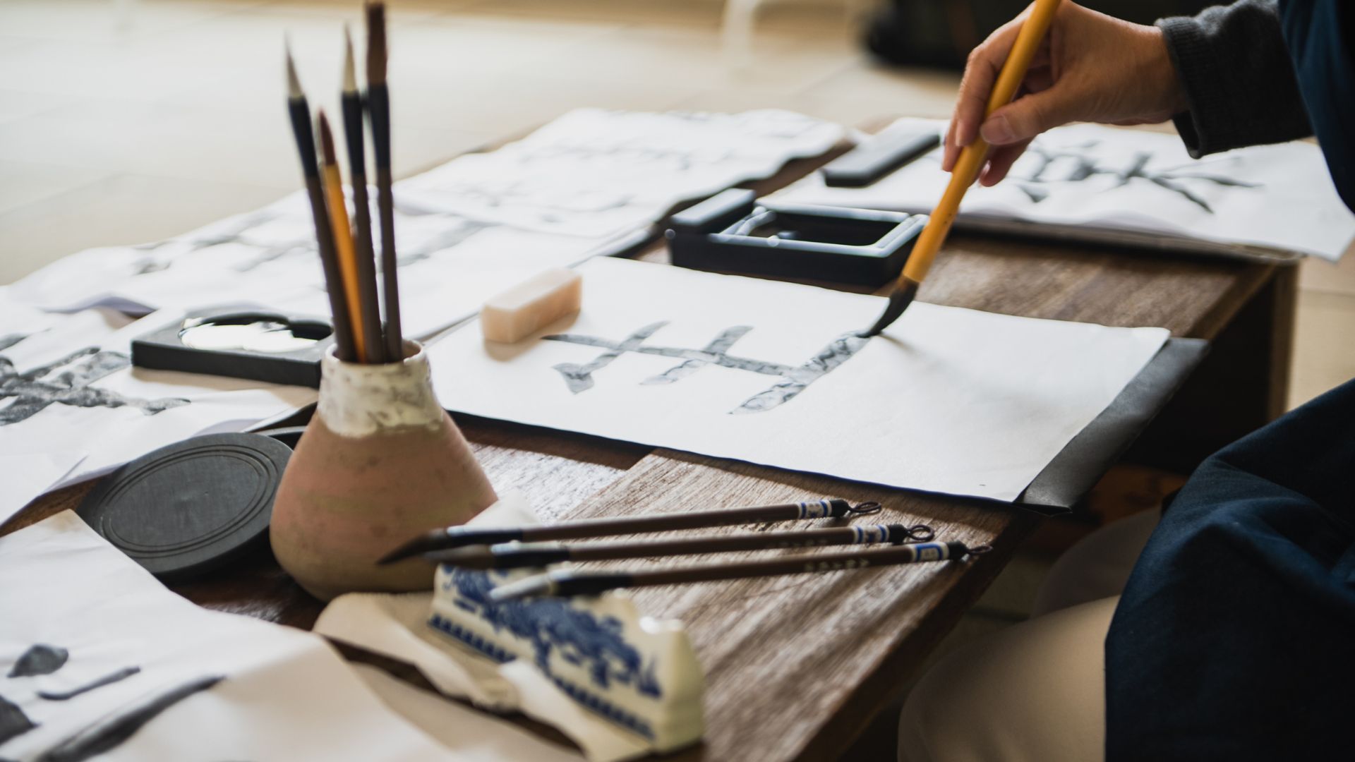 une personne qui pratique la calligraphie japonaise