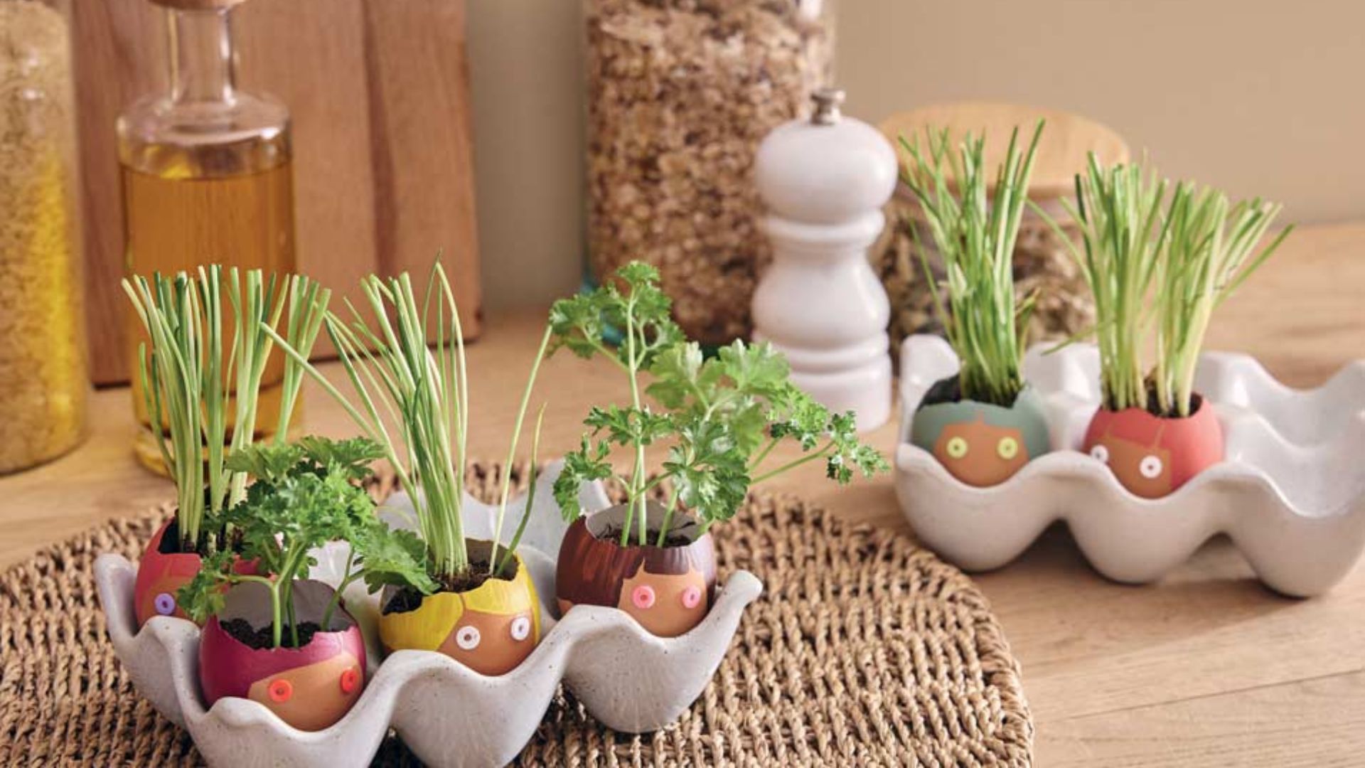 des coquilles d'oeufs peintes comme des bonhommes avec de la terre et des herbes aromatiques dedans 