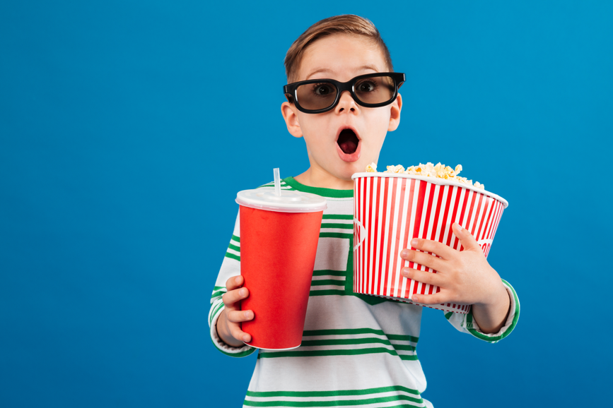 enfant avec boisson et pop corn se préparant à aller au ciné