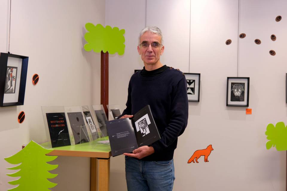un homme presente ses linogravures
