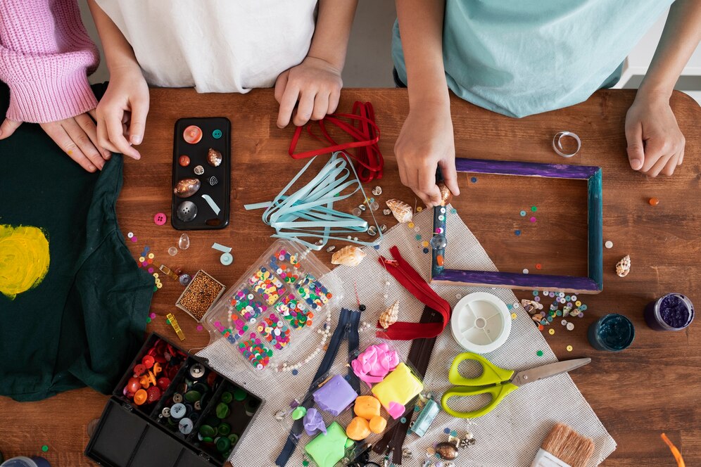 atelier paillettes et déco posés sur une table avec mains d'ado