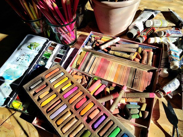 Photographie de pastels et autres crayons sur une table